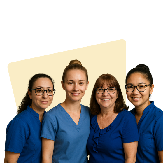 Four women in blue scrubs smiling, likely medical professionals, posing together.