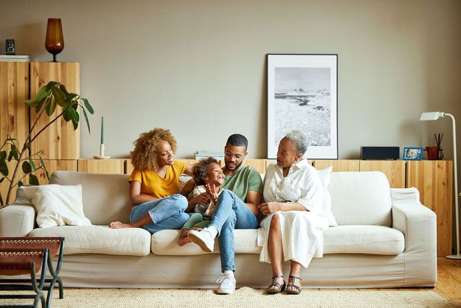 A family is sitting on a couch in a living room.