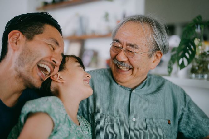 A family is laughing together in a living room.