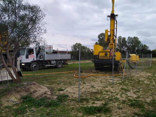 Donna con le cuffie sorride mentre guarda lo schermo del computer in ufficio.
