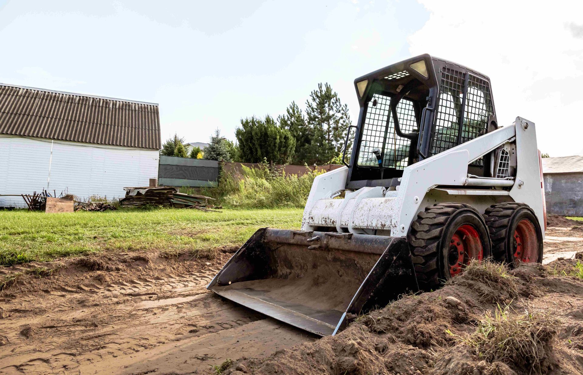 a bobcat skid steer is moving dirt in a field