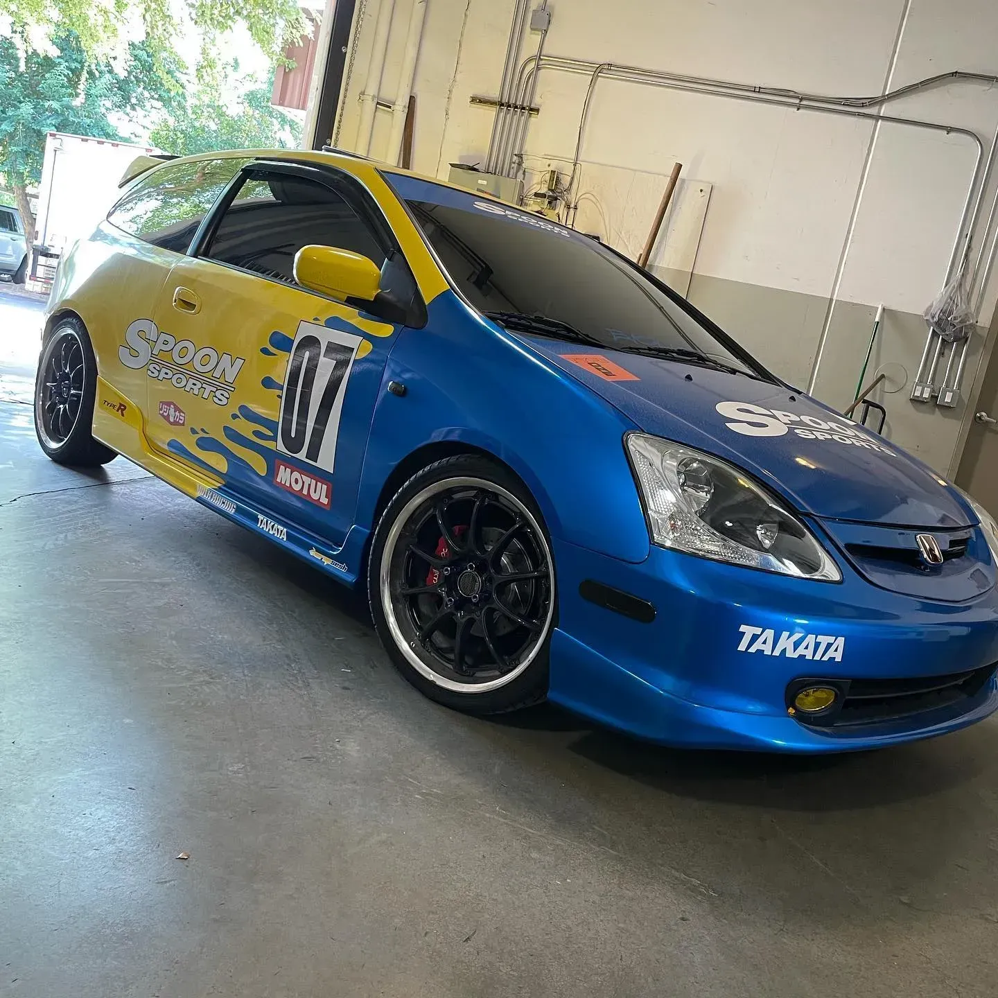 Blue and Yellow Race Car with Sponsor Decals | Wade's Automotive & Exhaust