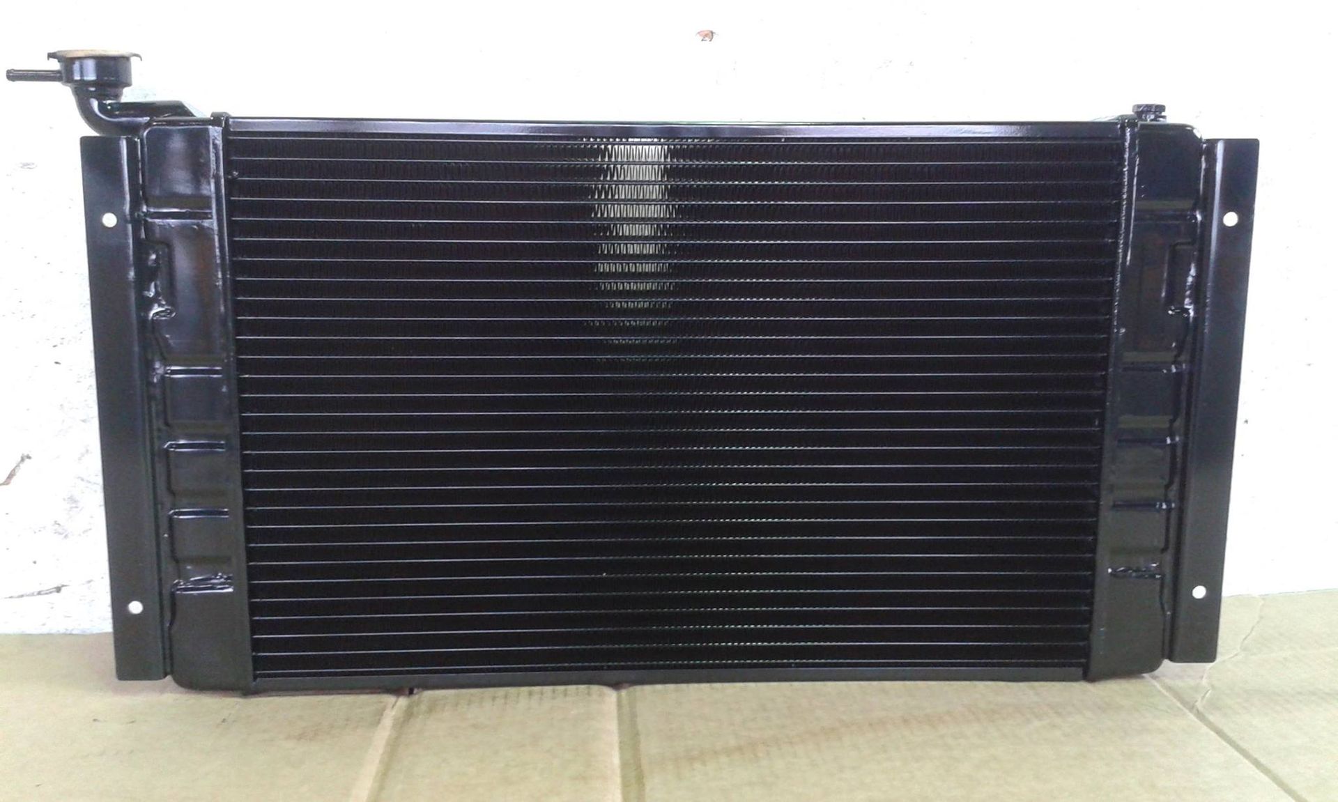 Black car radiator with a filler neck.