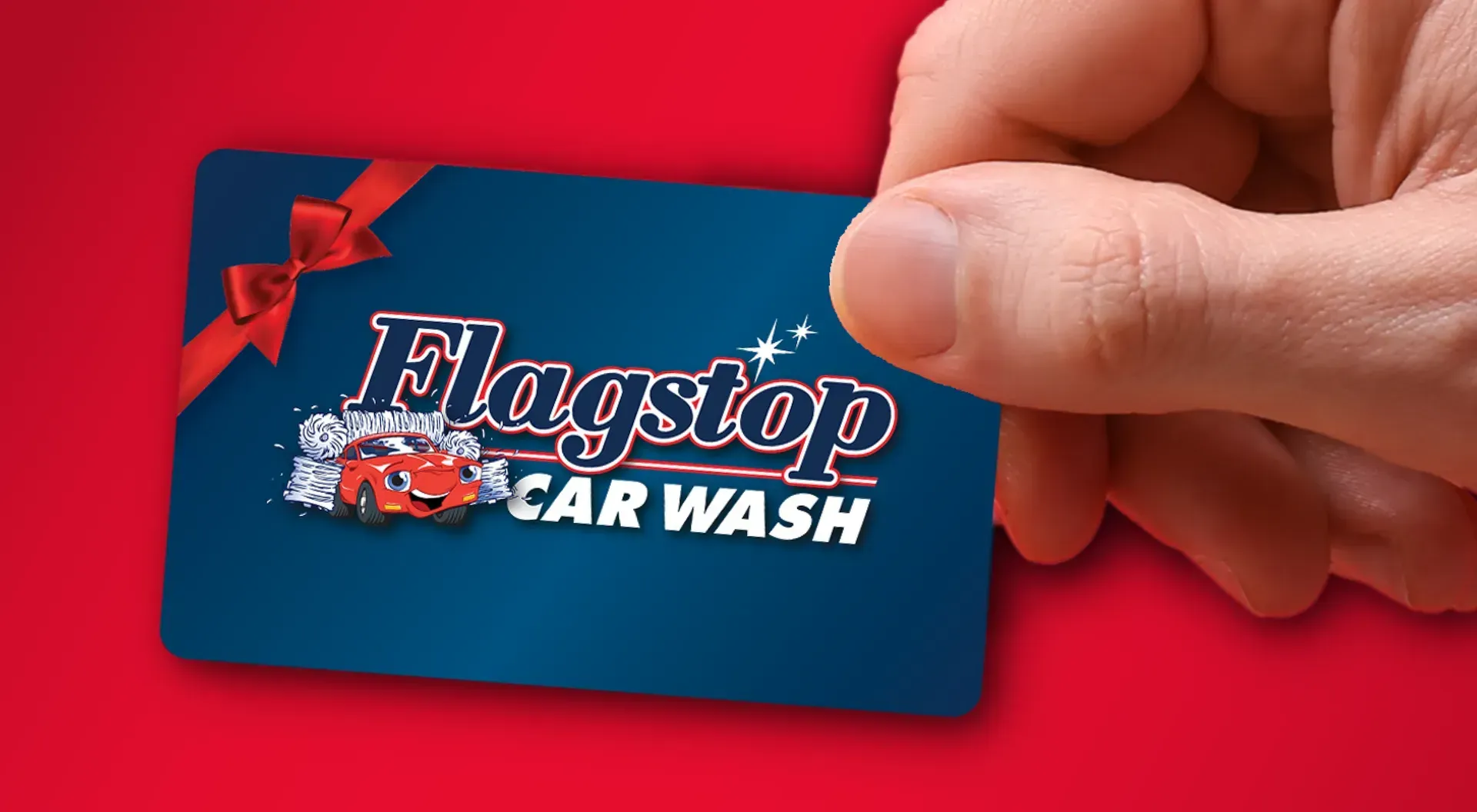 A person is holding a flagstop car wash gift card.