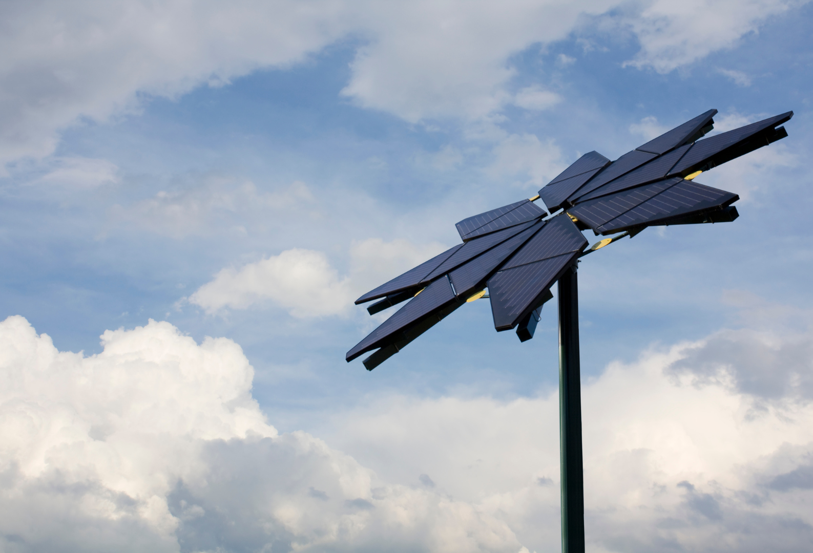 A large solar panel is against a cloudy blue sky.