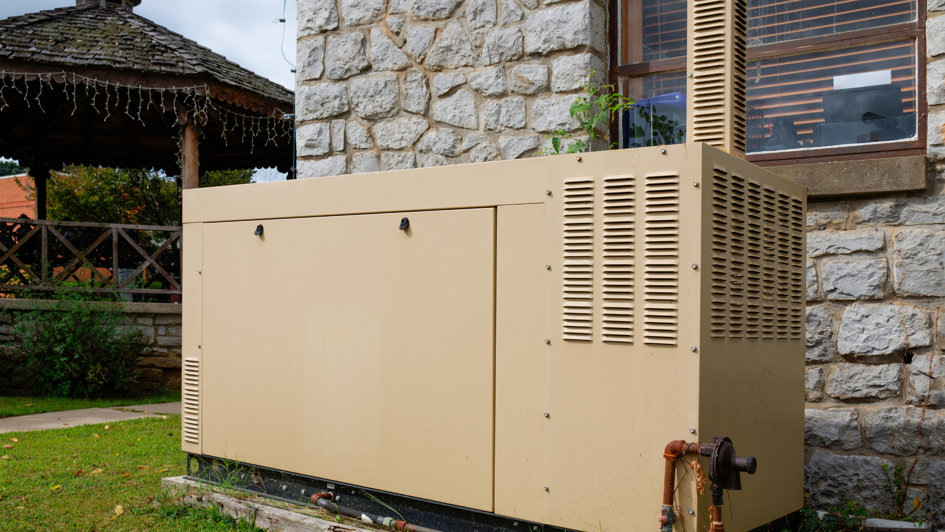 A generator is sitting in front of a stone building.