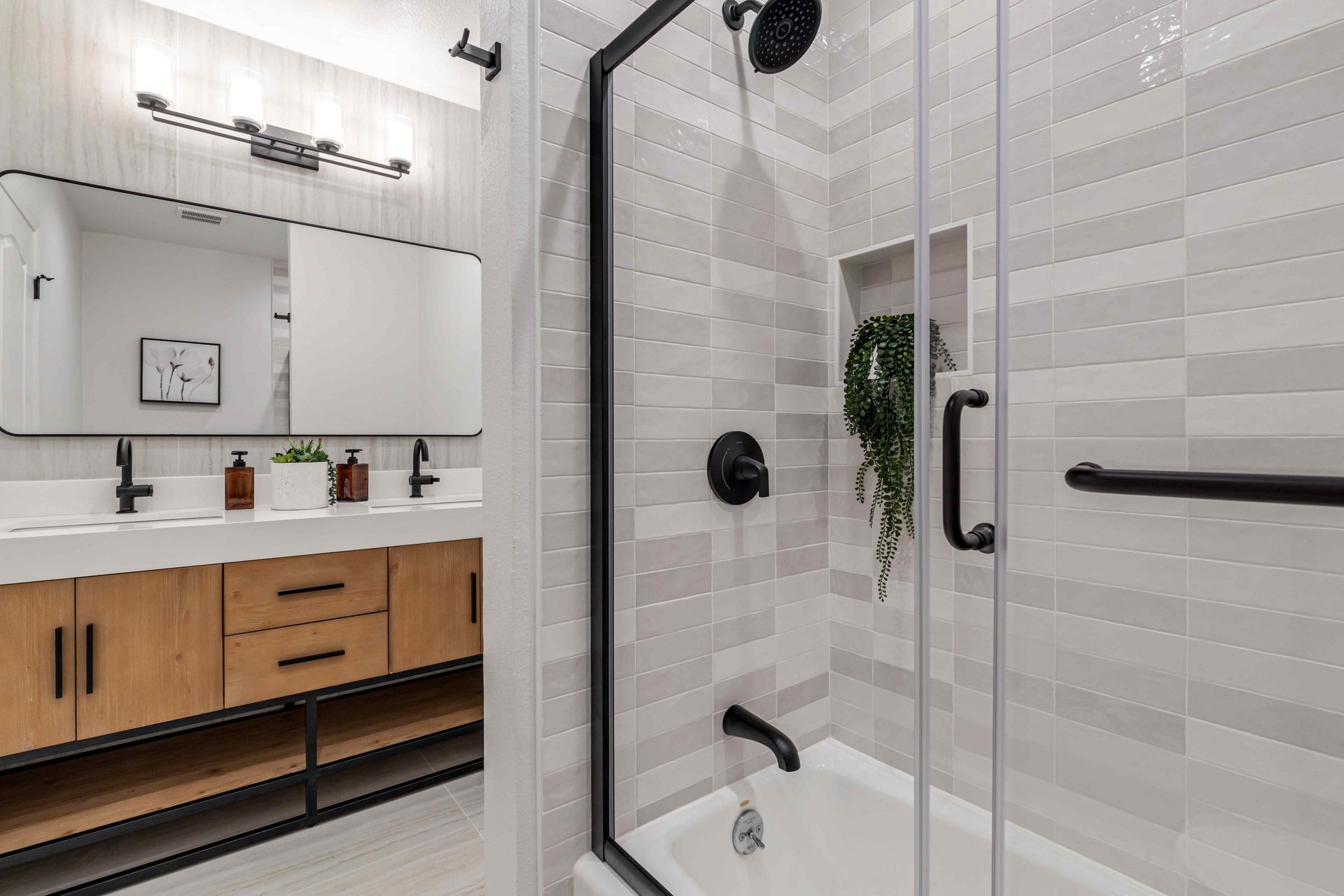 Open-concept kitchen and living room with white and gray cabinets, light wood floors, and modern furniture.