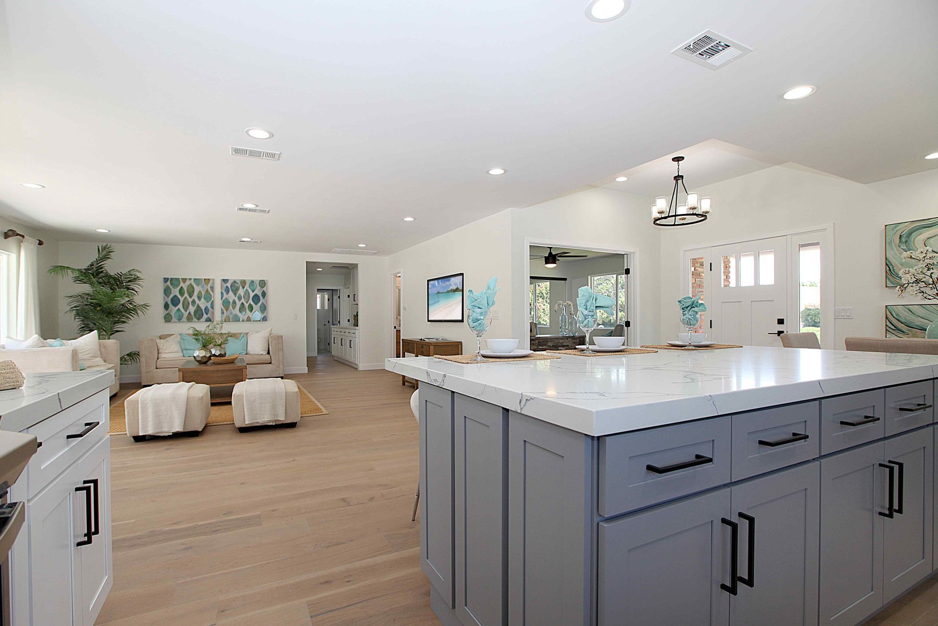 Spacious open-concept kitchen with light gray cabinets, white countertops, and a view into the living room.