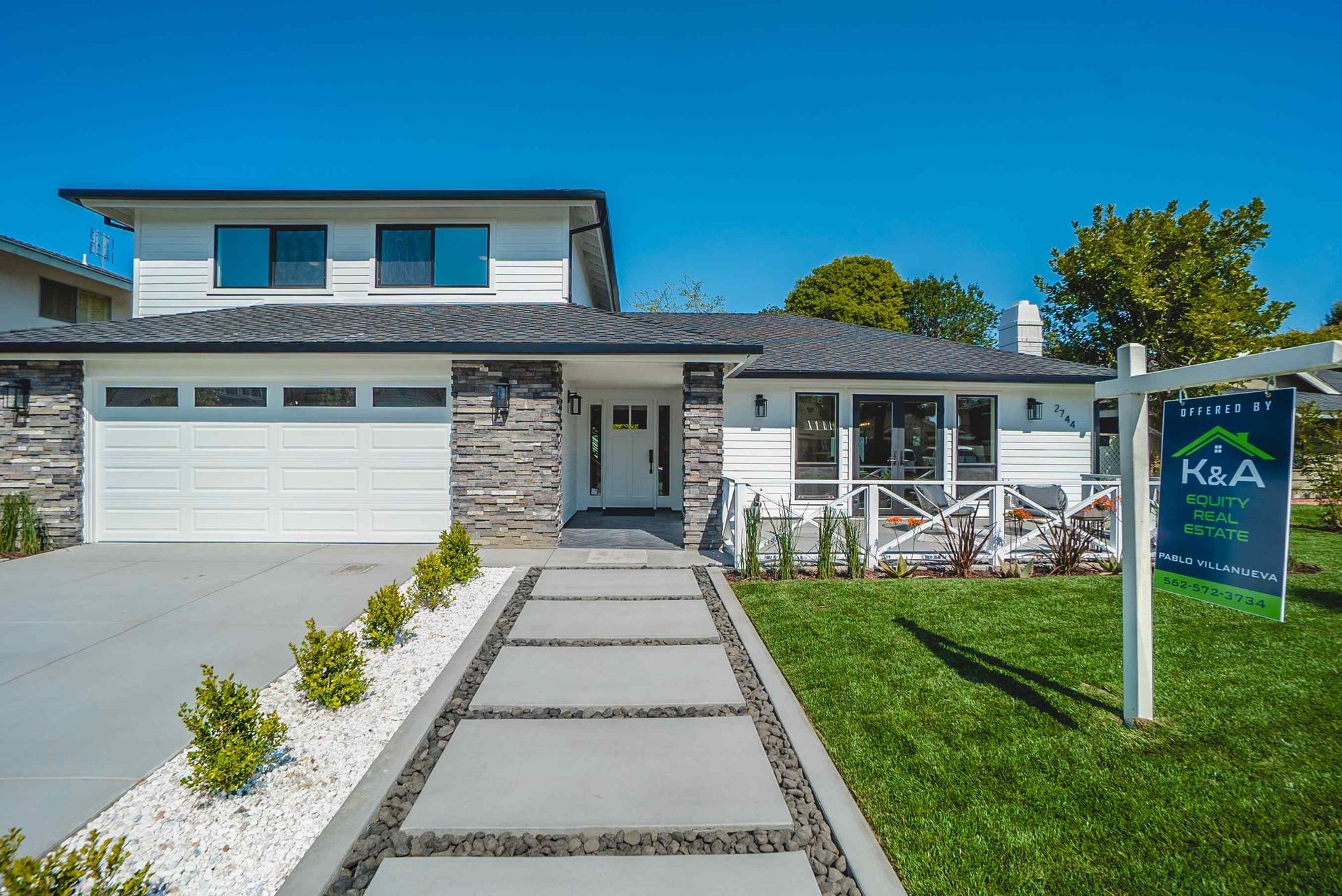 Modern white house with stone accents, lawn, and 