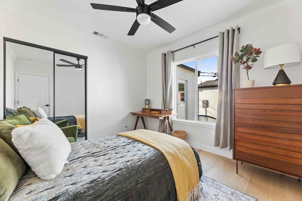 Bedroom with bed, dresser, desk, window, and ceiling fan. Green, white, and yellow accents.