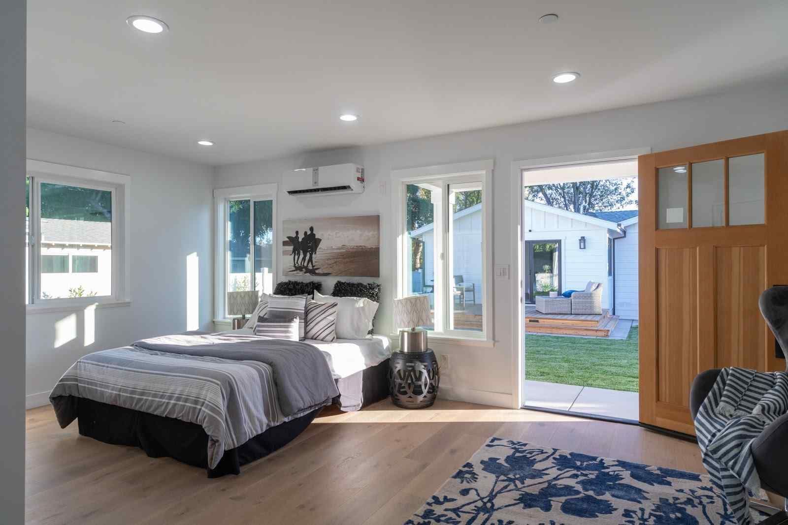 Cozy sitting area with two cream armchairs, a small table, and a large painting on a white wall.