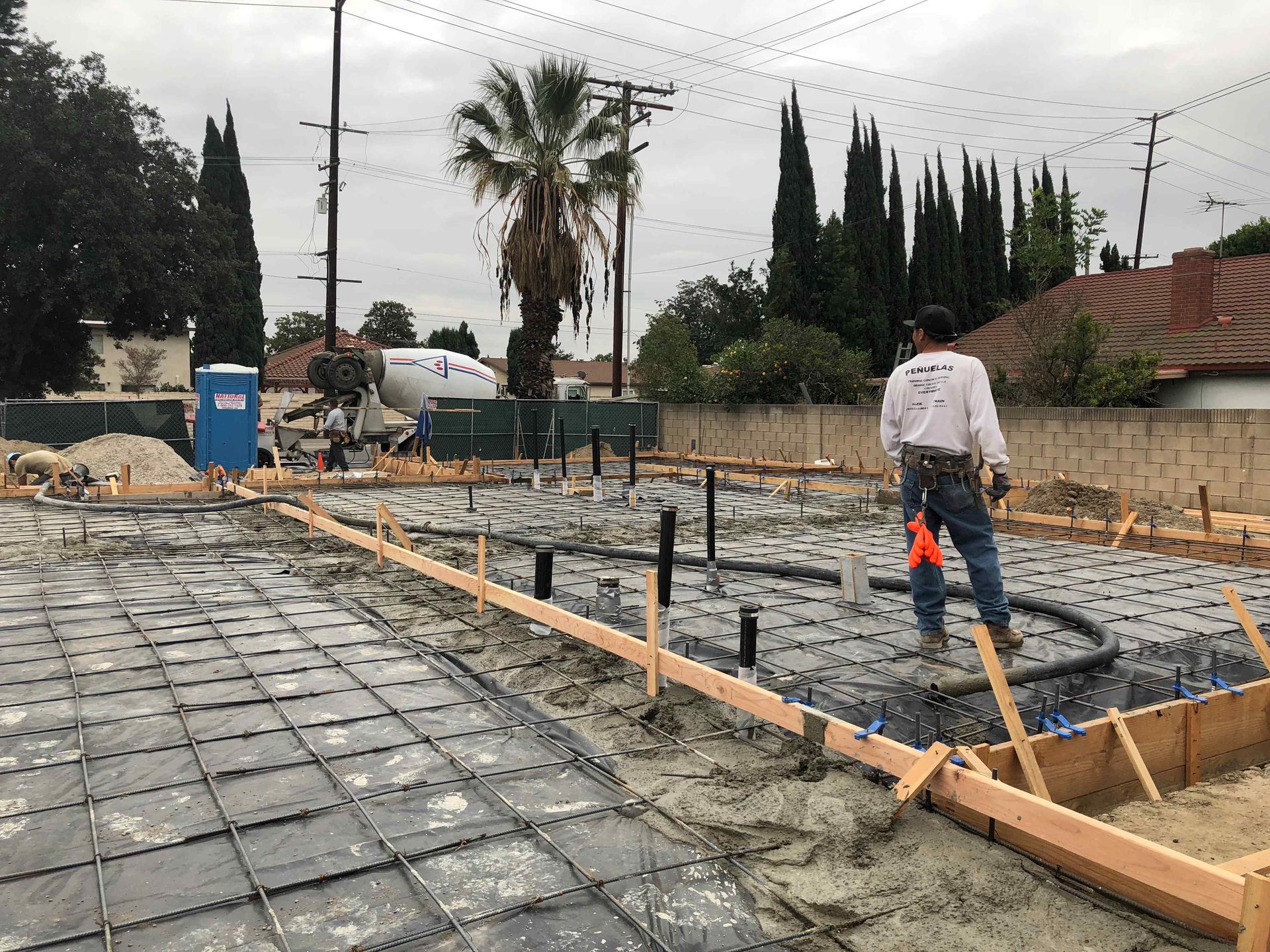 White house with black trim and patio, lush green lawn.