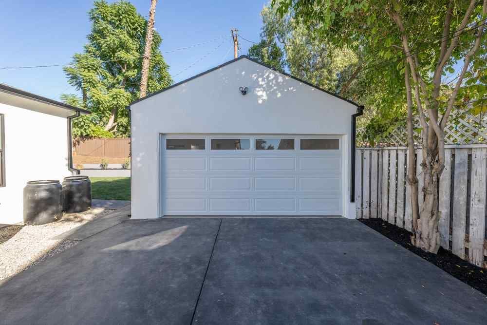 White garage with a closed door and a concrete driveway.