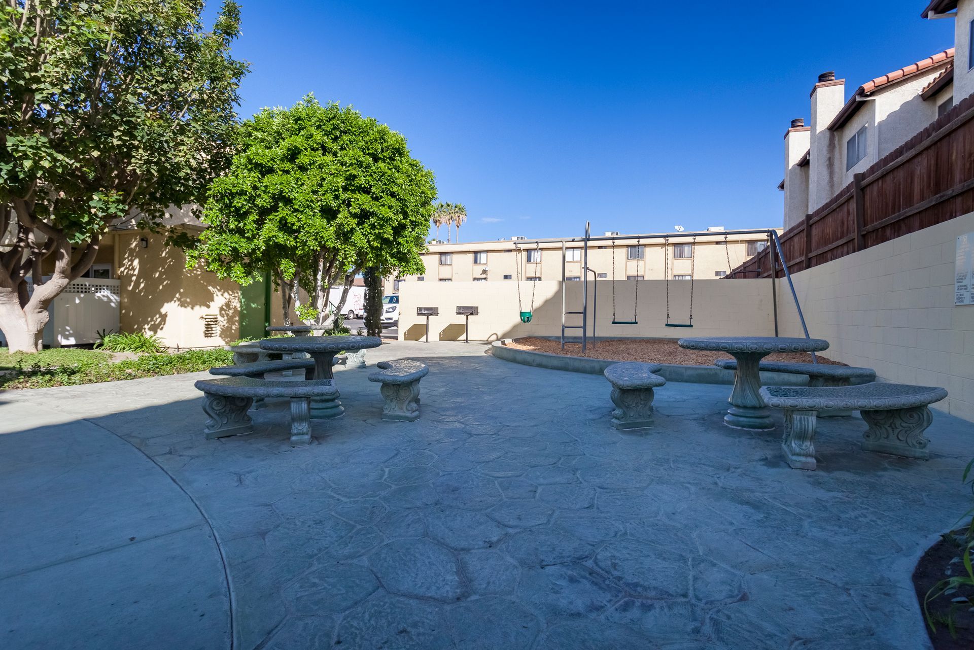 A picnic area with tables and benches in front of a building