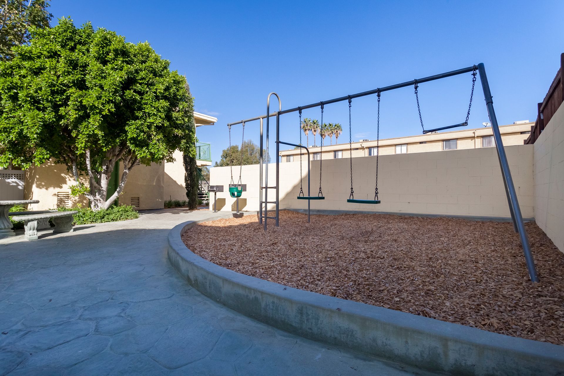 A playground with swings , a ladder and a picnic table