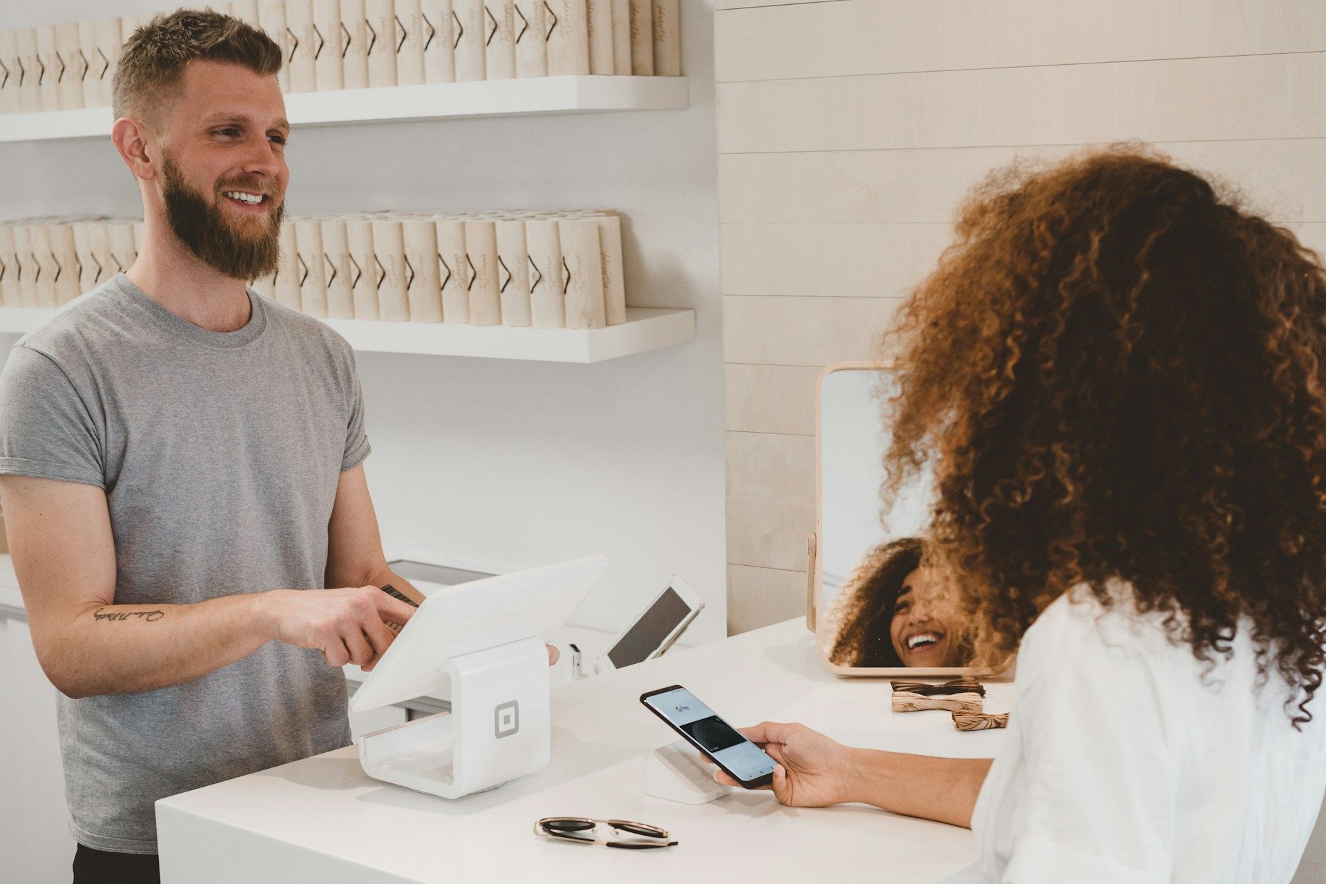 A man is talking to a woman at a counter in a store.