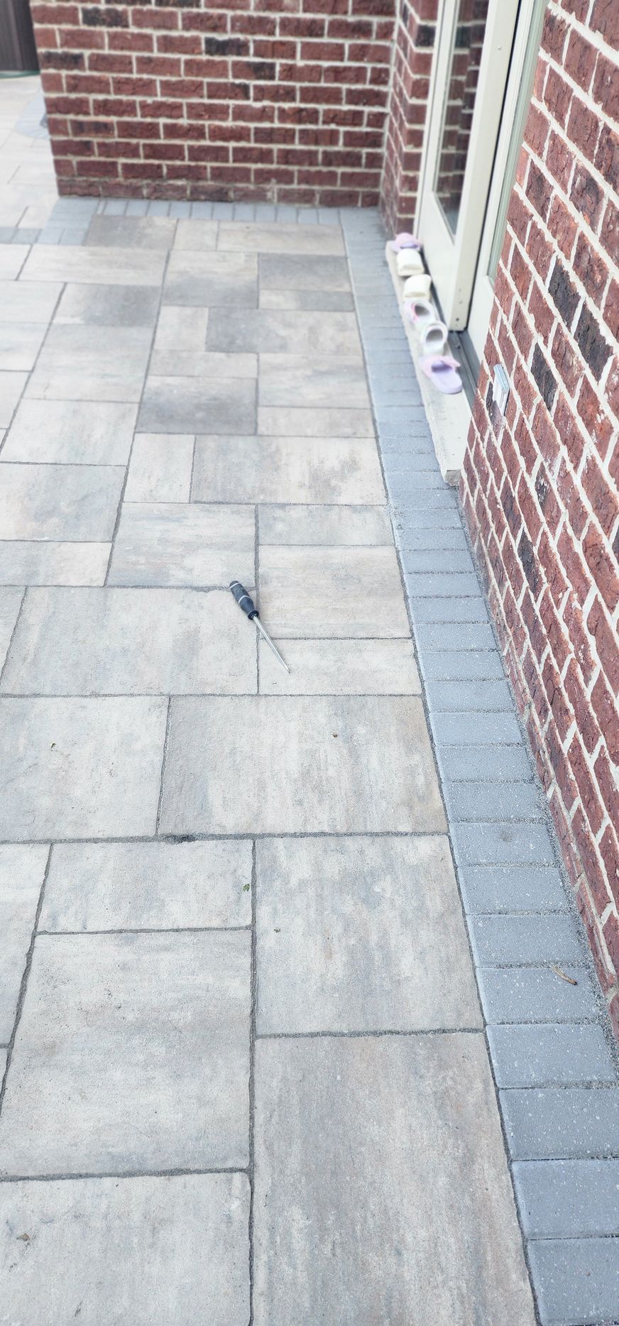 Stone patio next to a brick building.