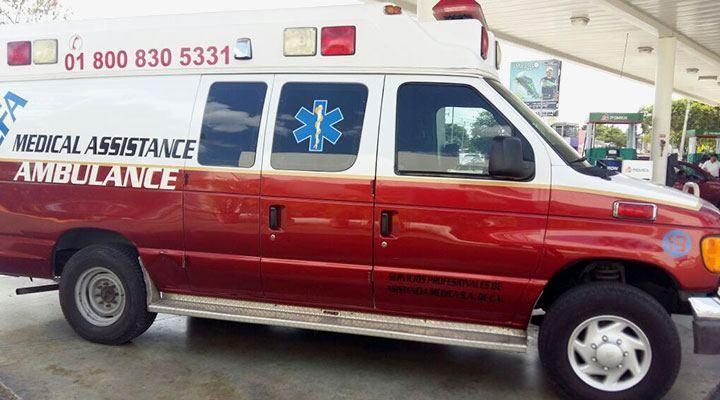 Ambulancia roja y blanca con el símbolo de la estrella de la vida estacionada en una gasolinera.