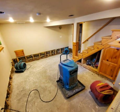 Commercial dehumidifiers drying out a flooded basement during restoration.