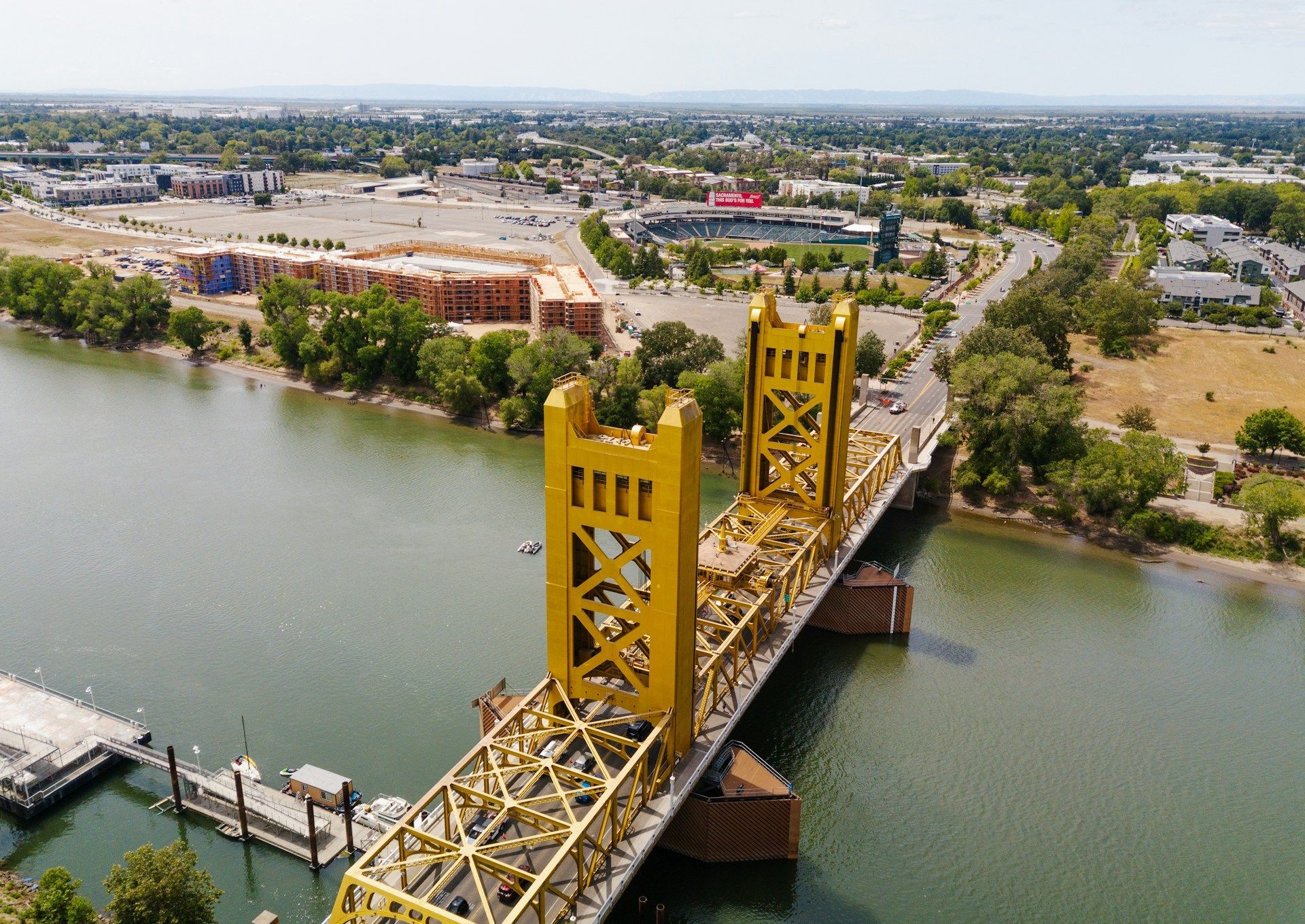 An aerial view of a yellow bridge over a river.