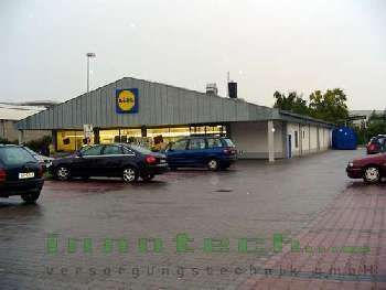 Vor einem Geschäft parken viele Autos.