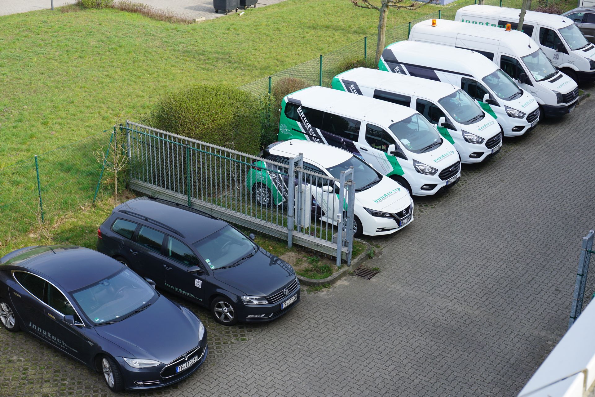 Auf einem Parkplatz steht eine Reihe von Autos und Lieferwagen.