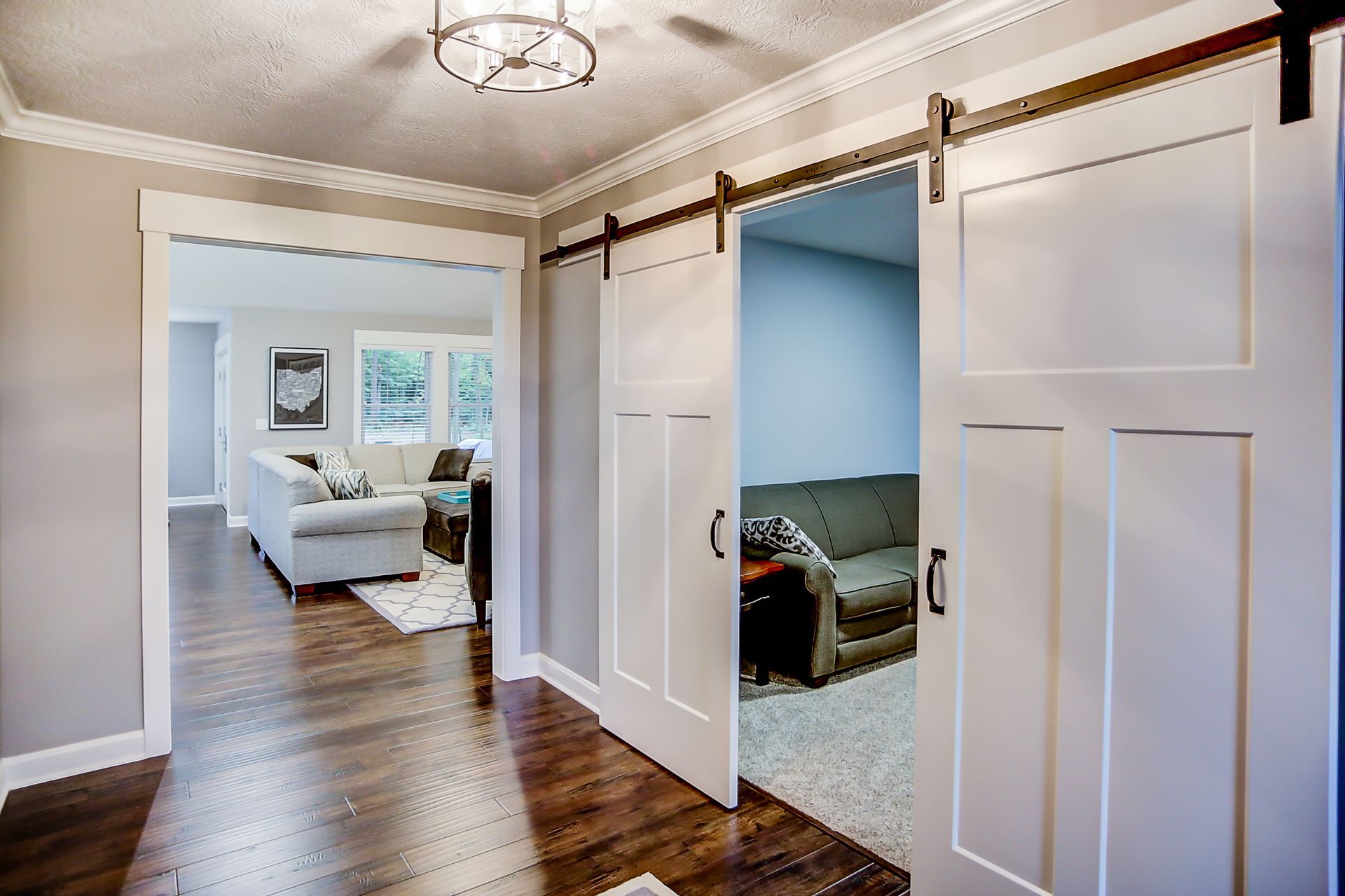 A hallway with sliding barn doors leading to a living room.