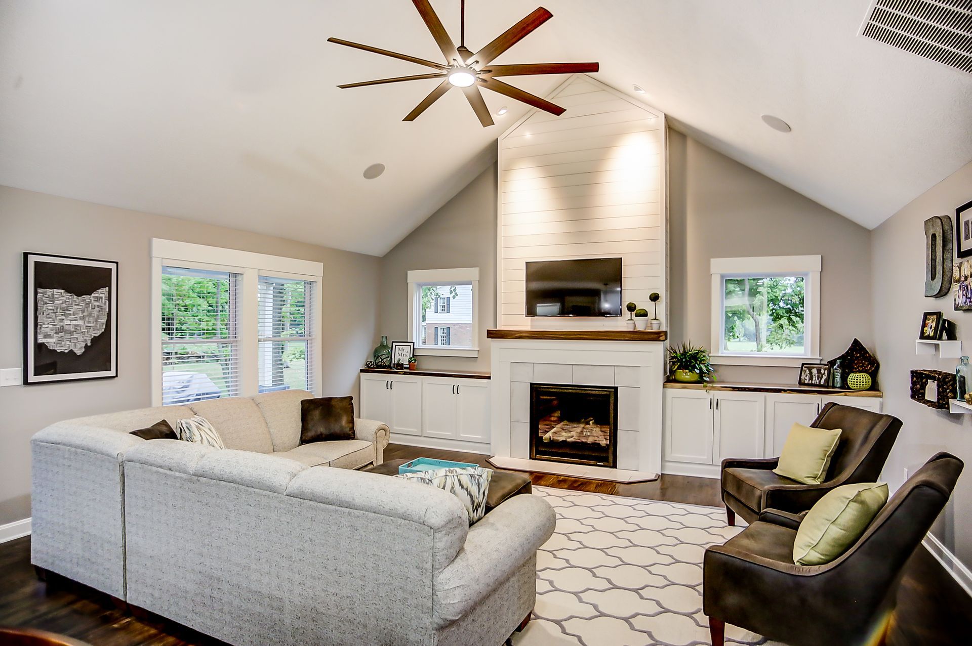 A living room with a fireplace and a ceiling fan
