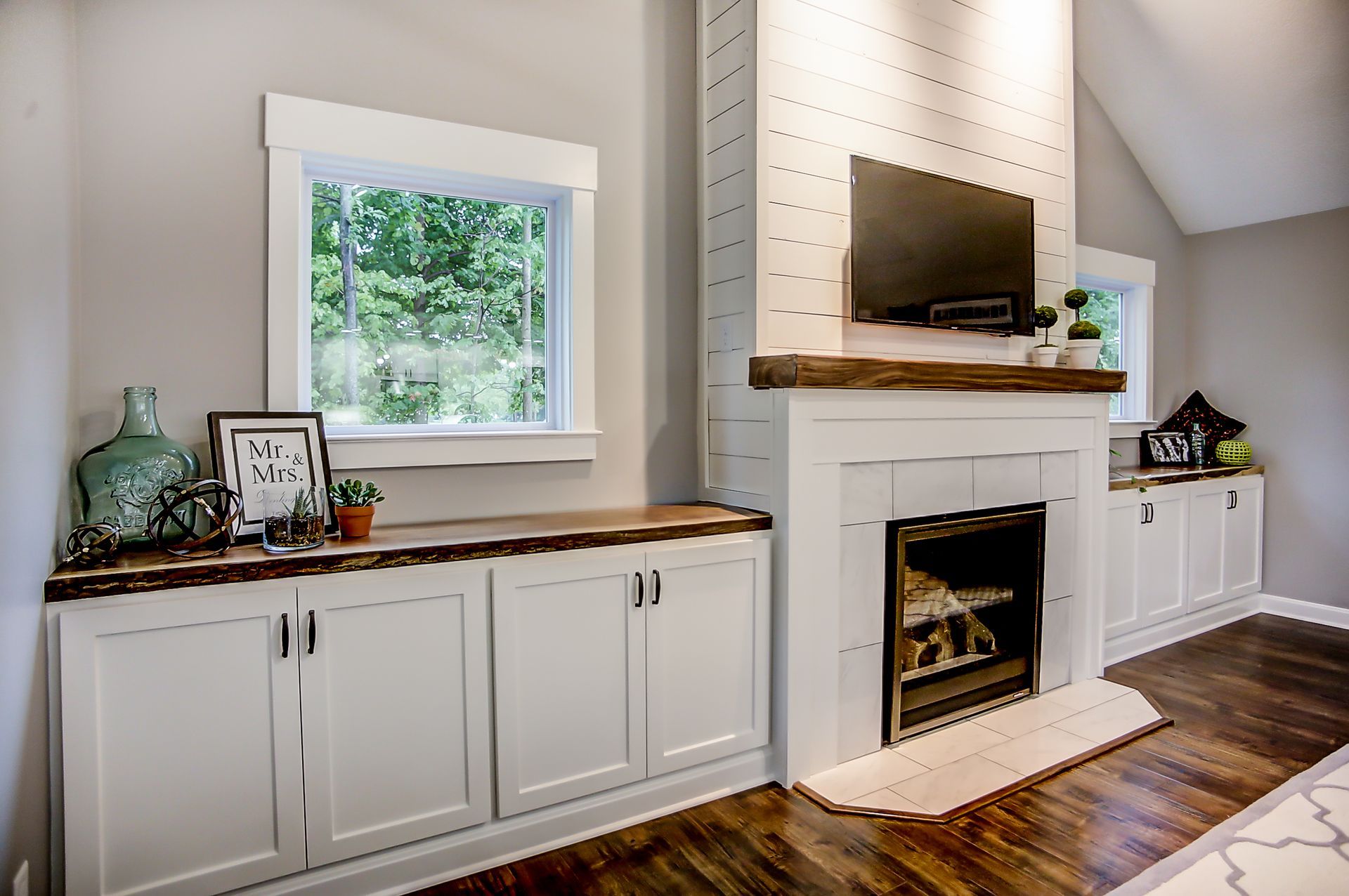 A living room with a fireplace and a television on the wall.
