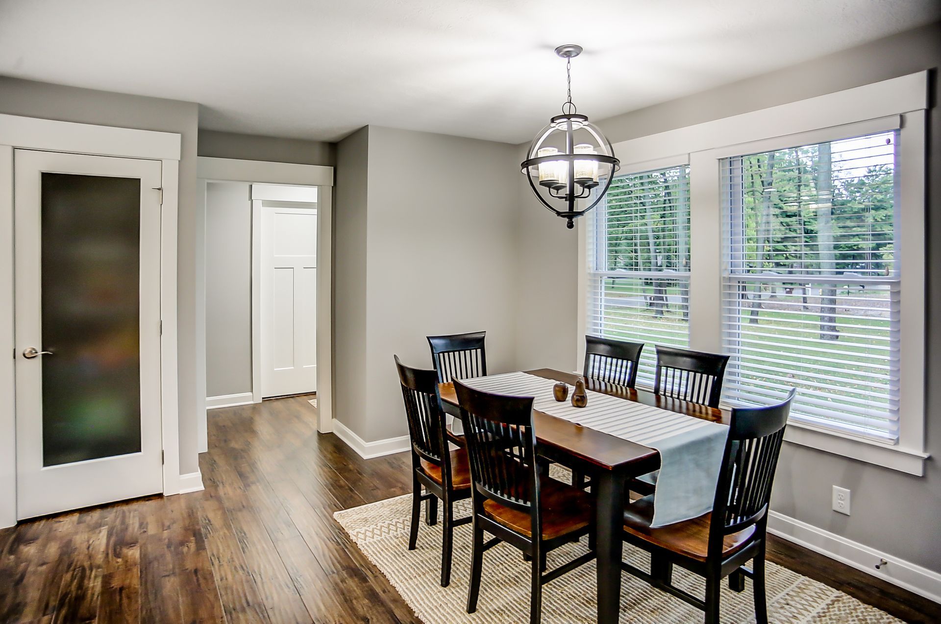 A dining room with a table and chairs and a chandelier.
