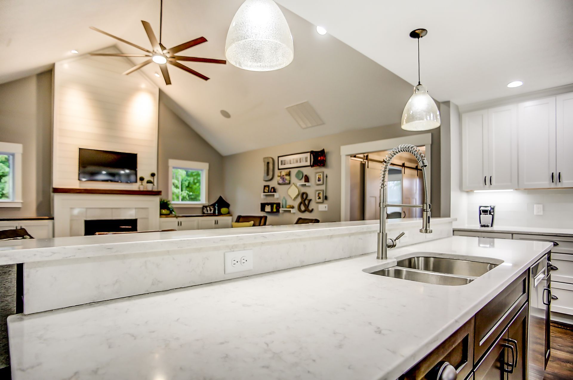 A kitchen with a sink and a ceiling fan