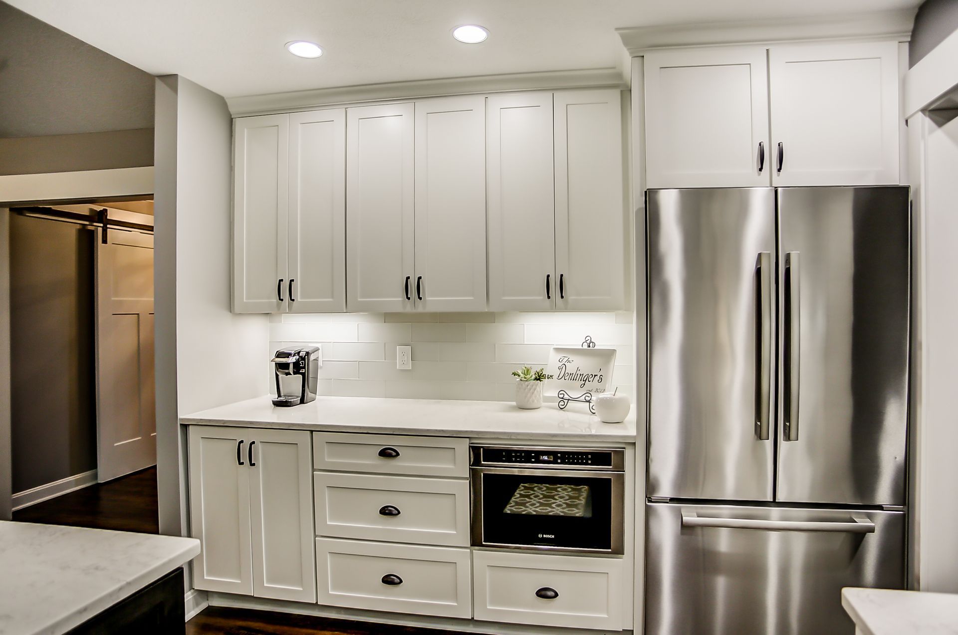 A kitchen with white cabinets and stainless steel appliances.
