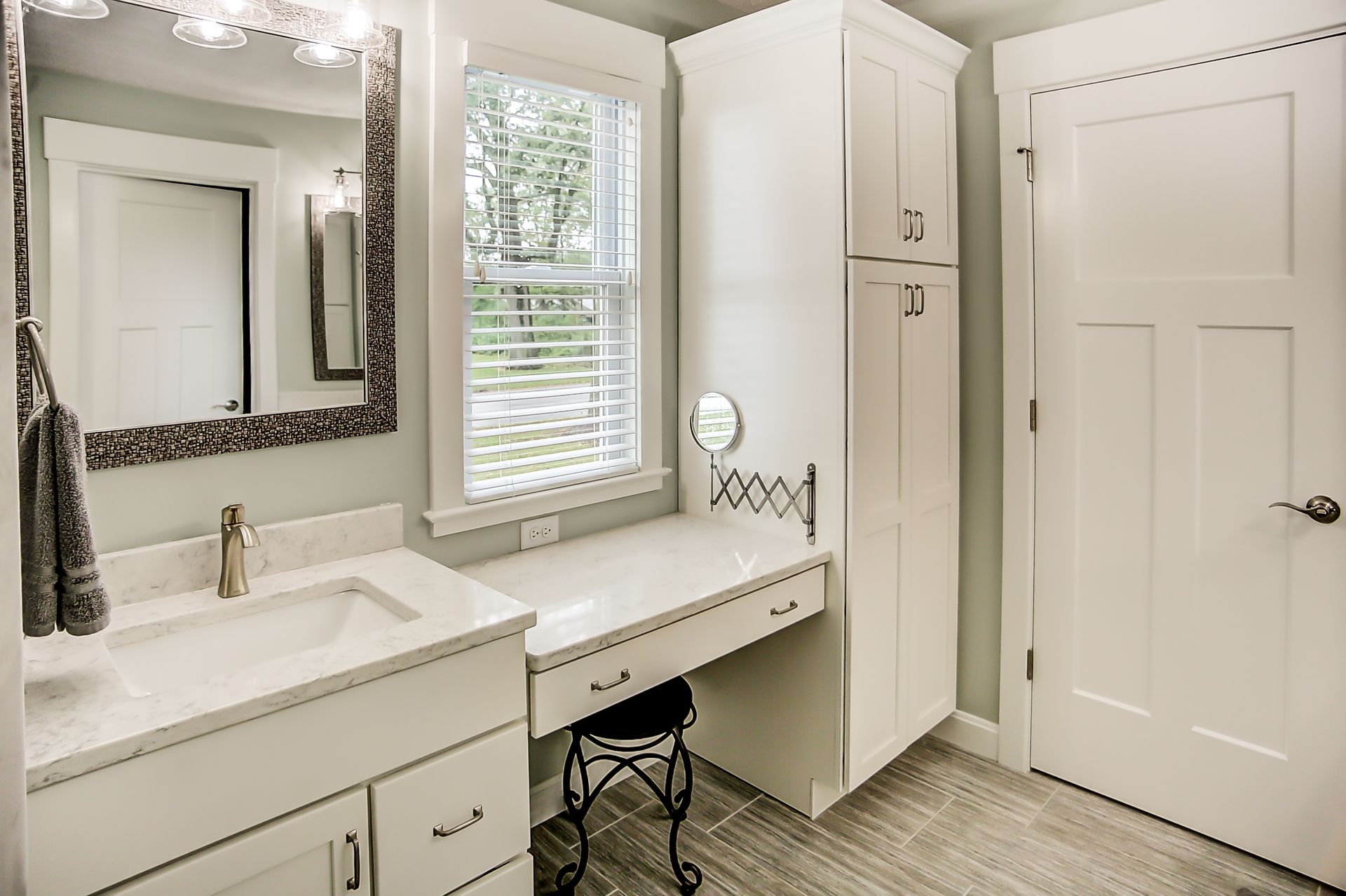 A bathroom with a sink , mirror and vanity.