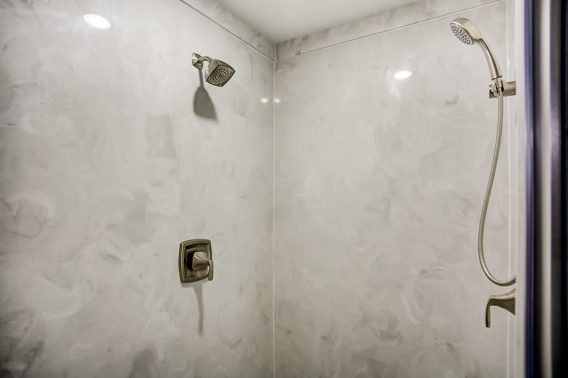 A shower with a shower head and a shower head attached to the wall.