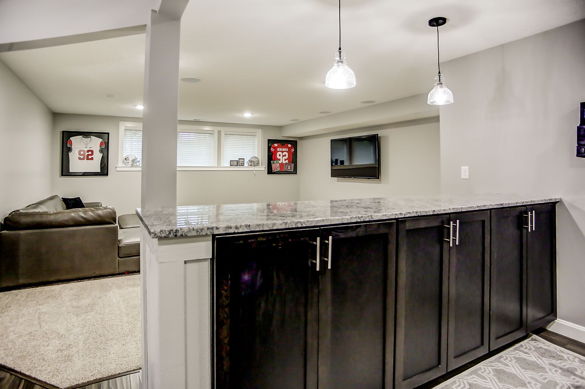 A kitchen with black cabinets and a granite counter top