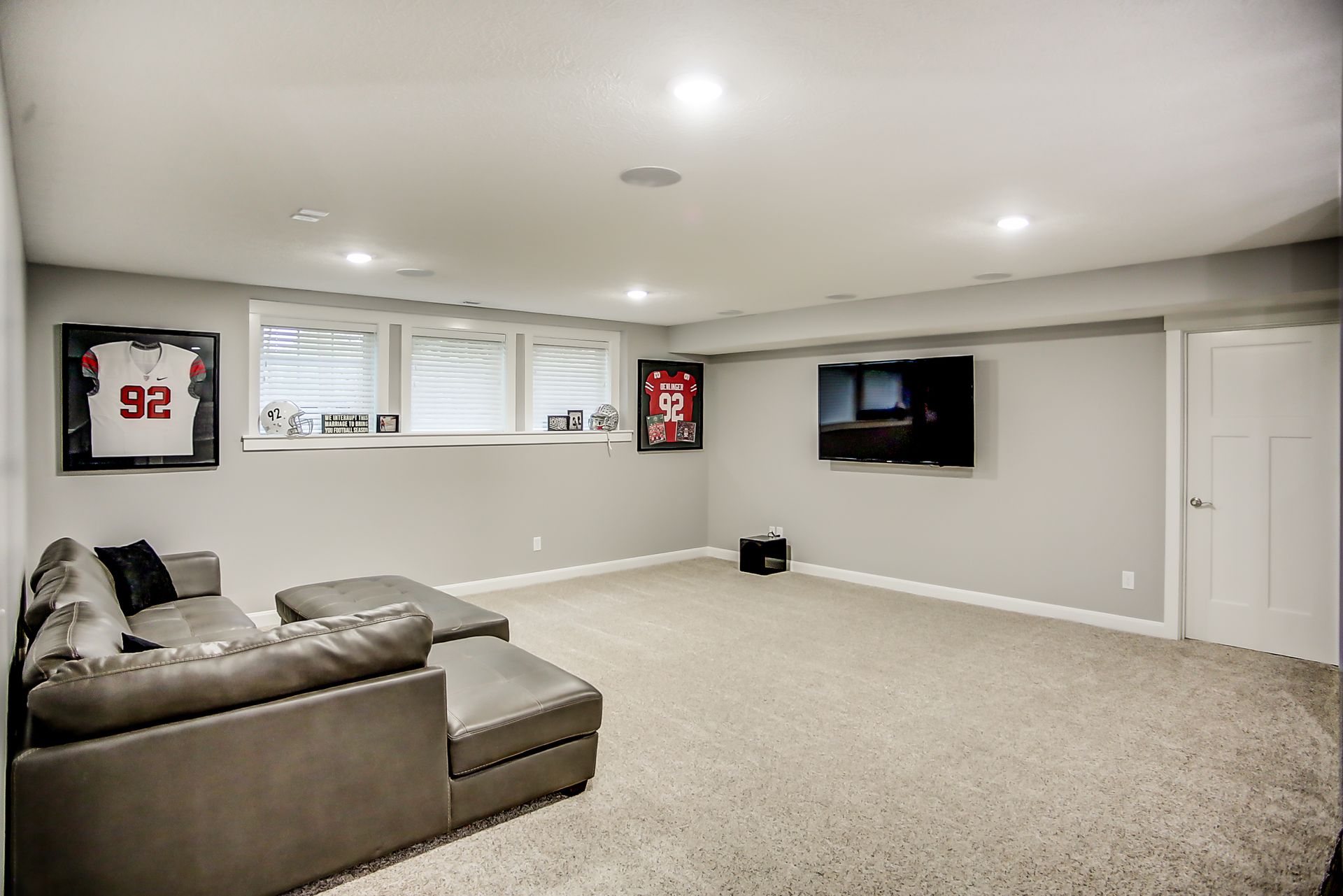 A living room with a couch and a television on the wall.