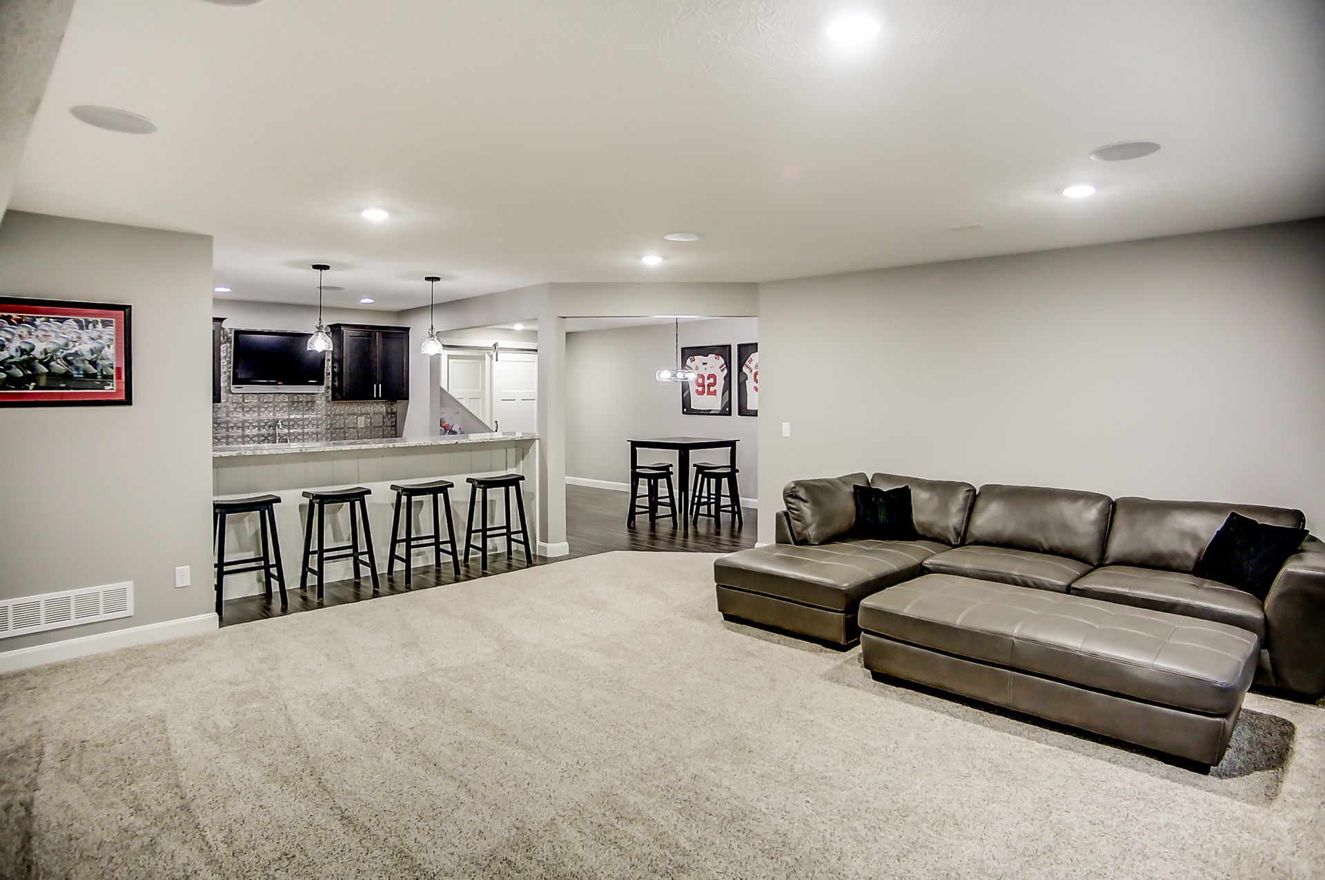 A living room with a couch and stools in a basement.