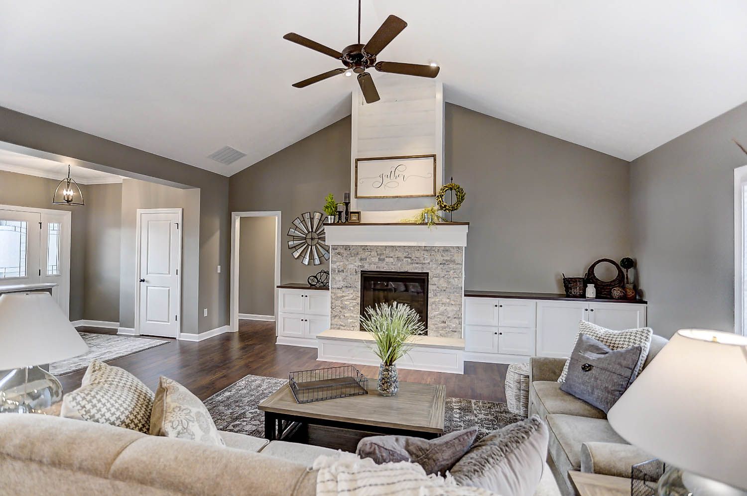 A living room filled with furniture and a fireplace with a ceiling fan.