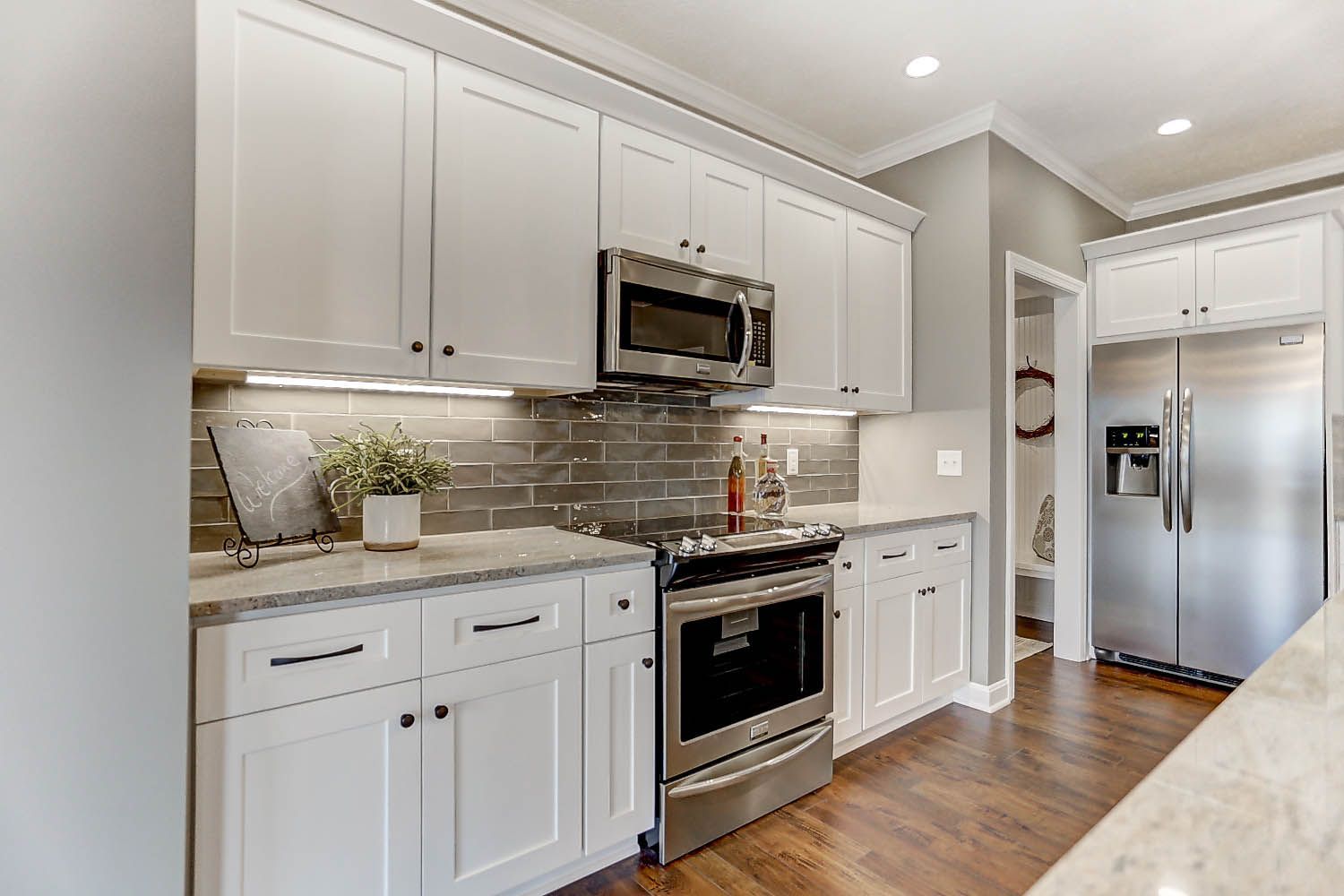 A kitchen with white cabinets and stainless steel appliances.