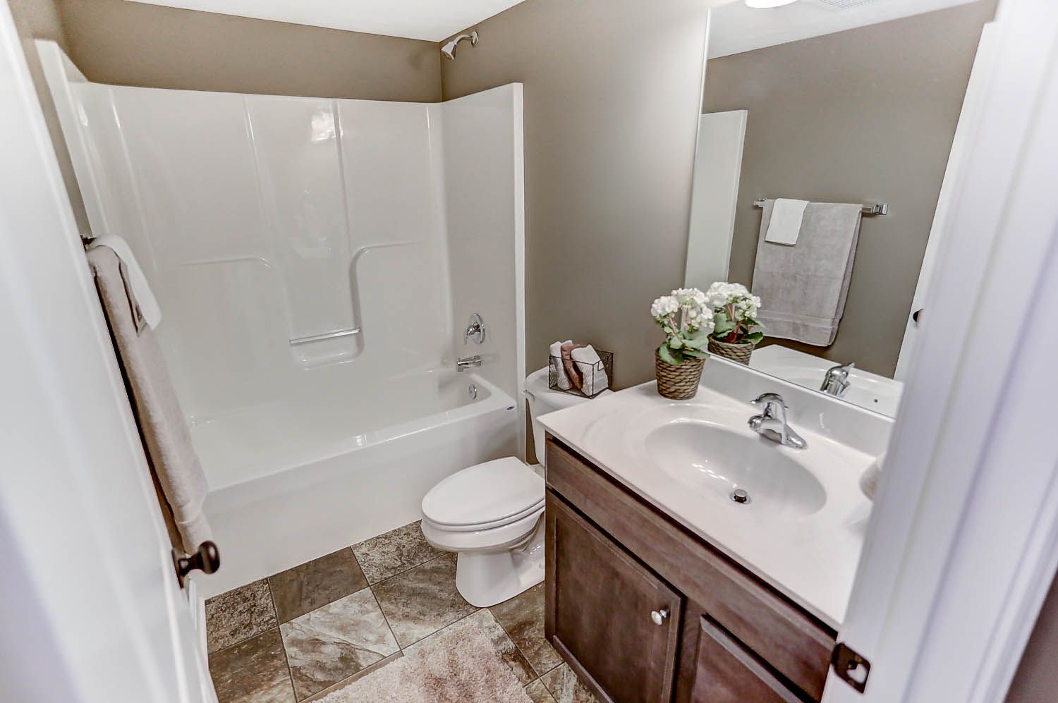 A bathroom with a sink , toilet , bathtub and mirror.