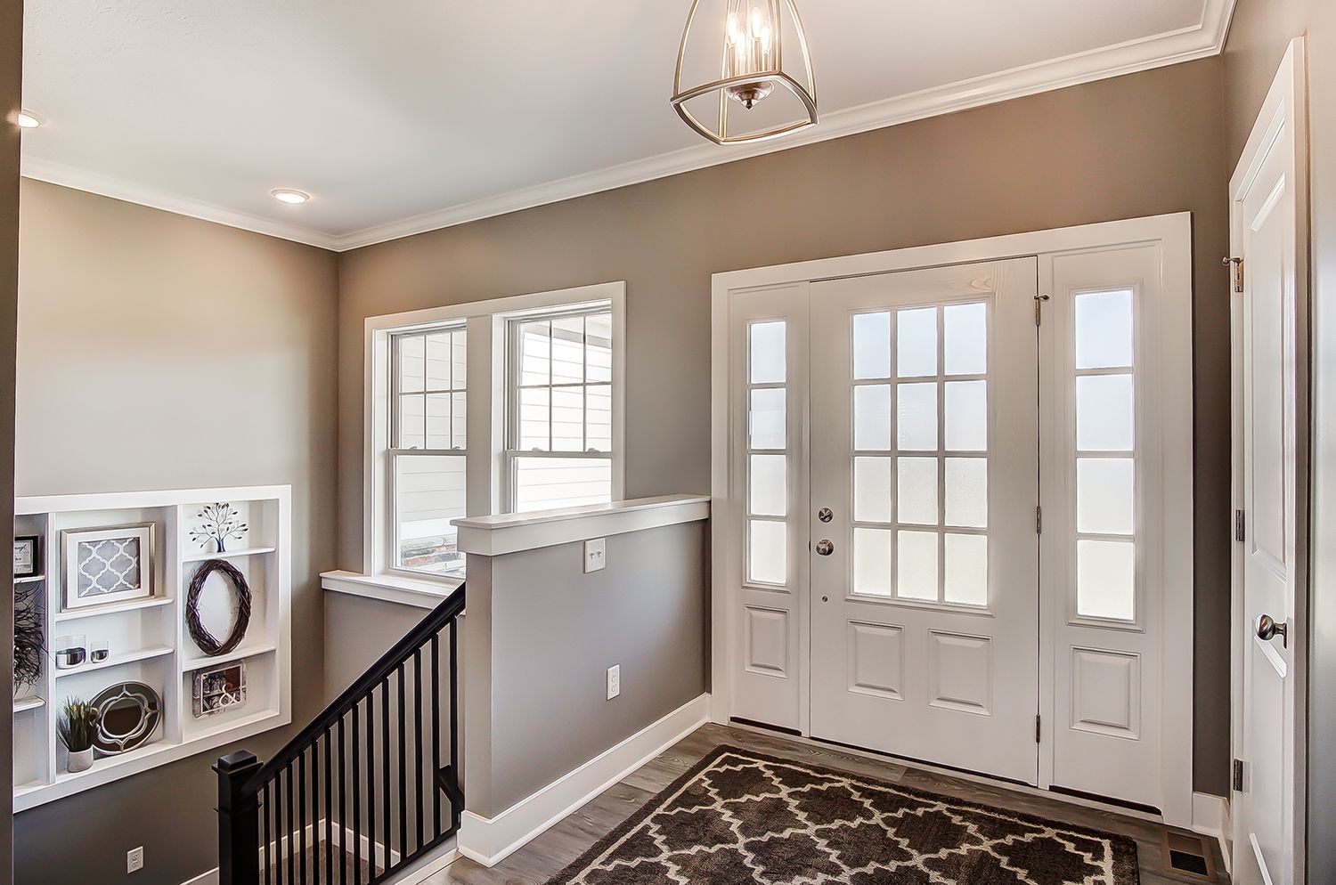 A hallway with a staircase leading up to the second floor of a house.
