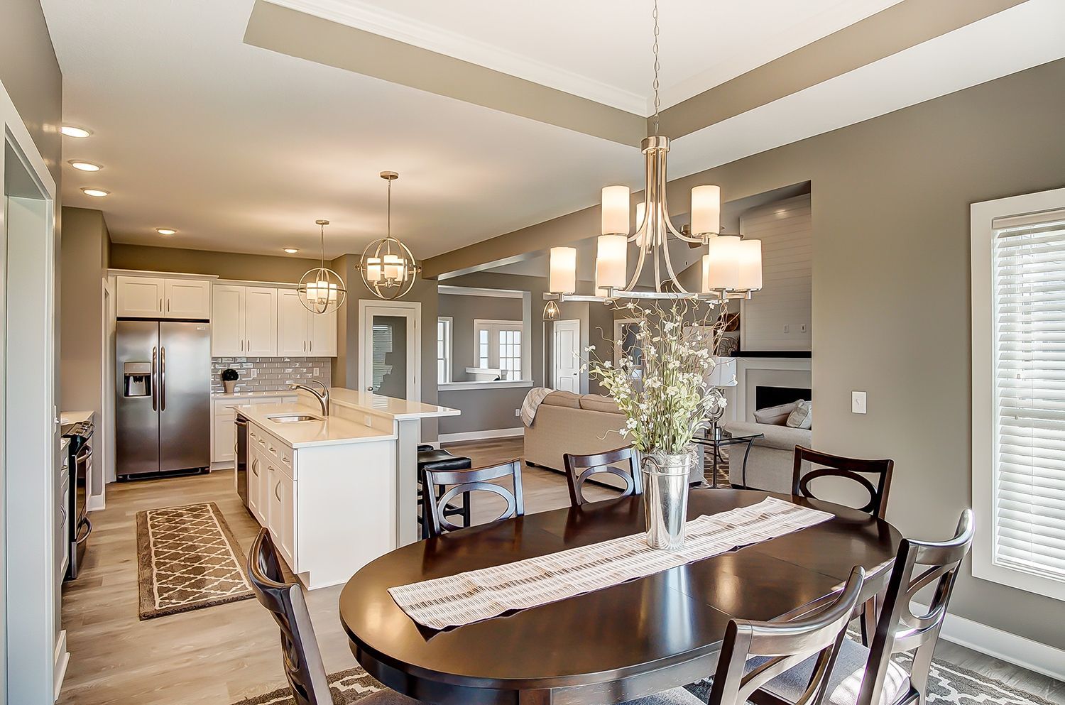 A dining room table and chairs in a house with a chandelier.