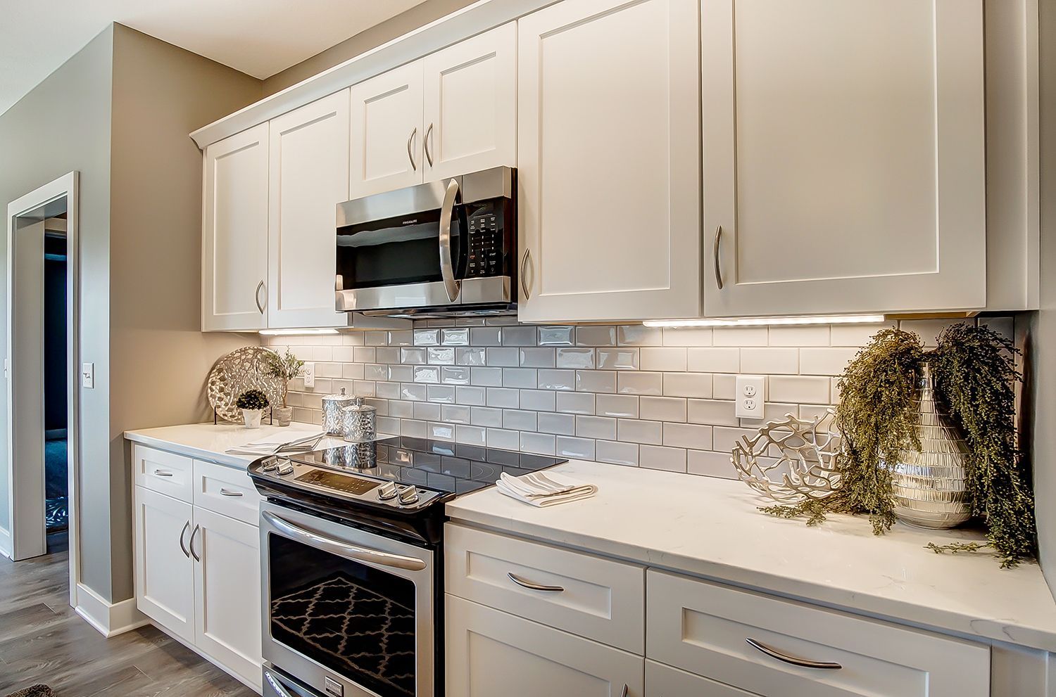 A kitchen with white cabinets and stainless steel appliances.