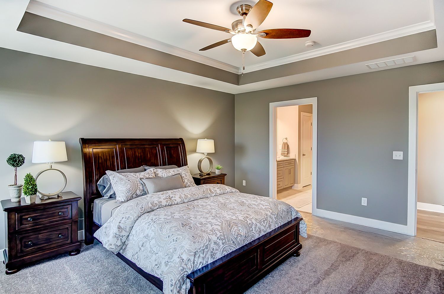 A bedroom with a bed , nightstand , and ceiling fan.