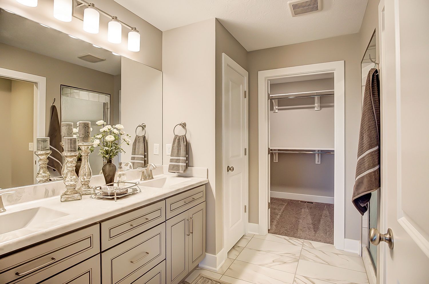 A bathroom with a walk in closet and a sink.