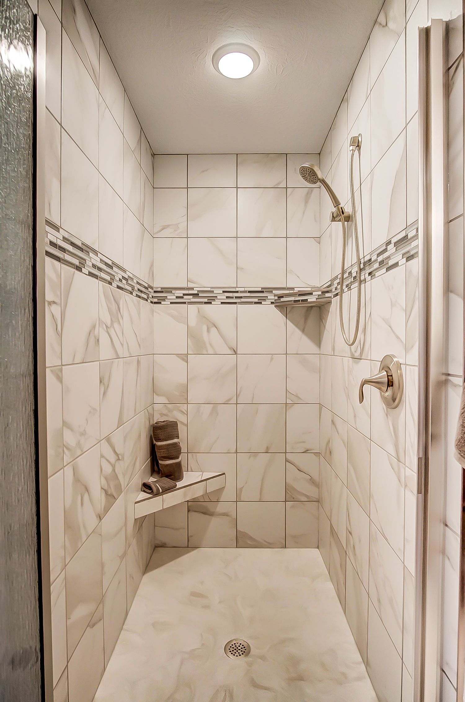 A bathroom with a walk in shower and a shower head.