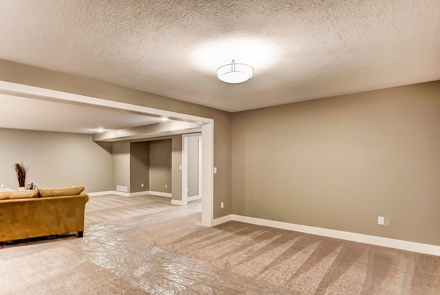 There is a couch in the middle of the room in the basement.
