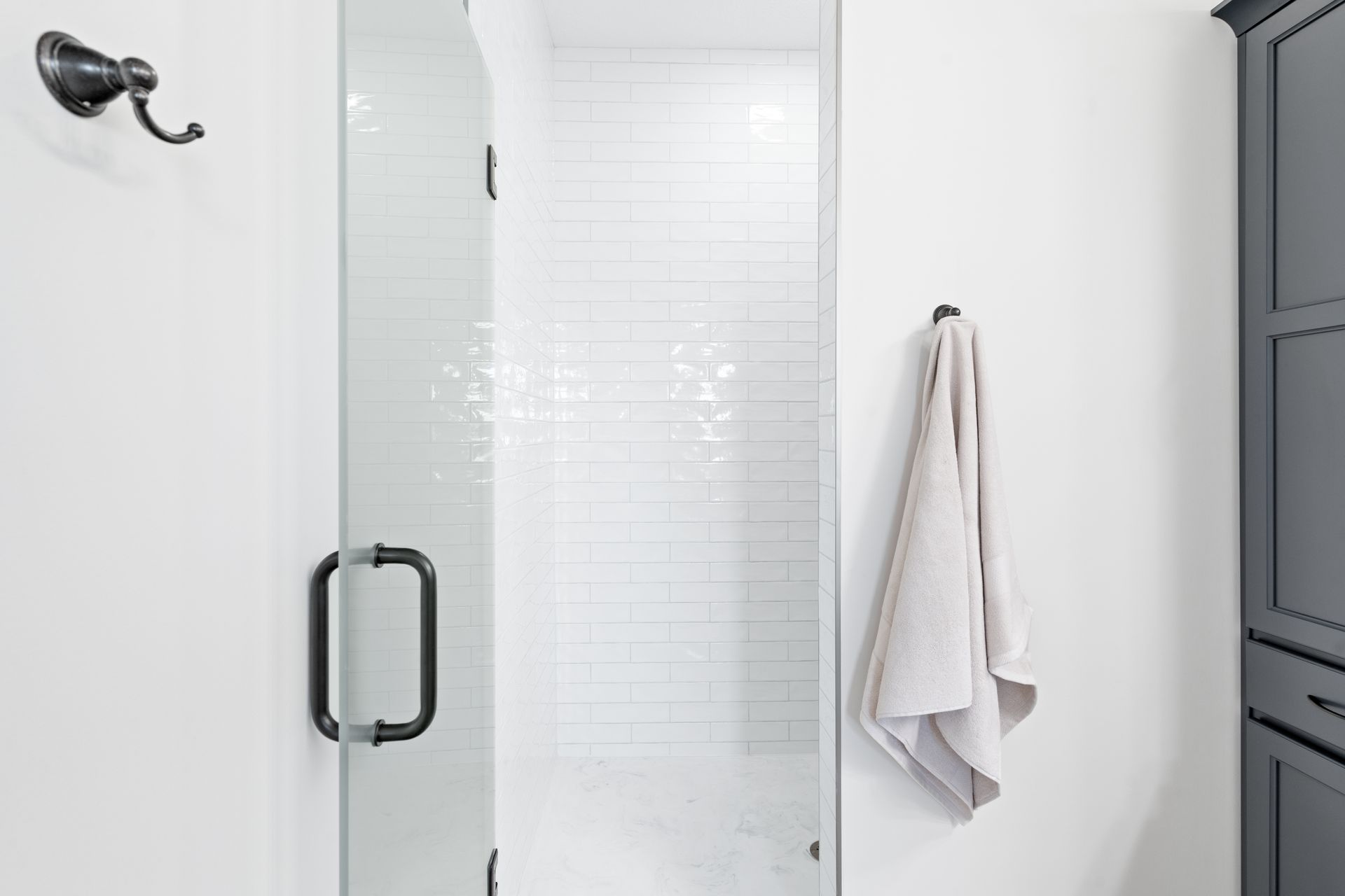 A bathroom with a shower and a towel hanging on the wall.
