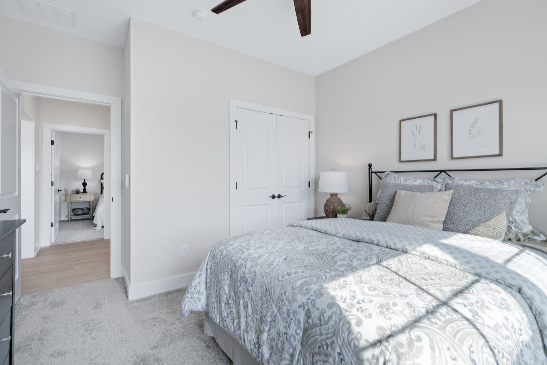 A bedroom with a large bed and a ceiling fan.