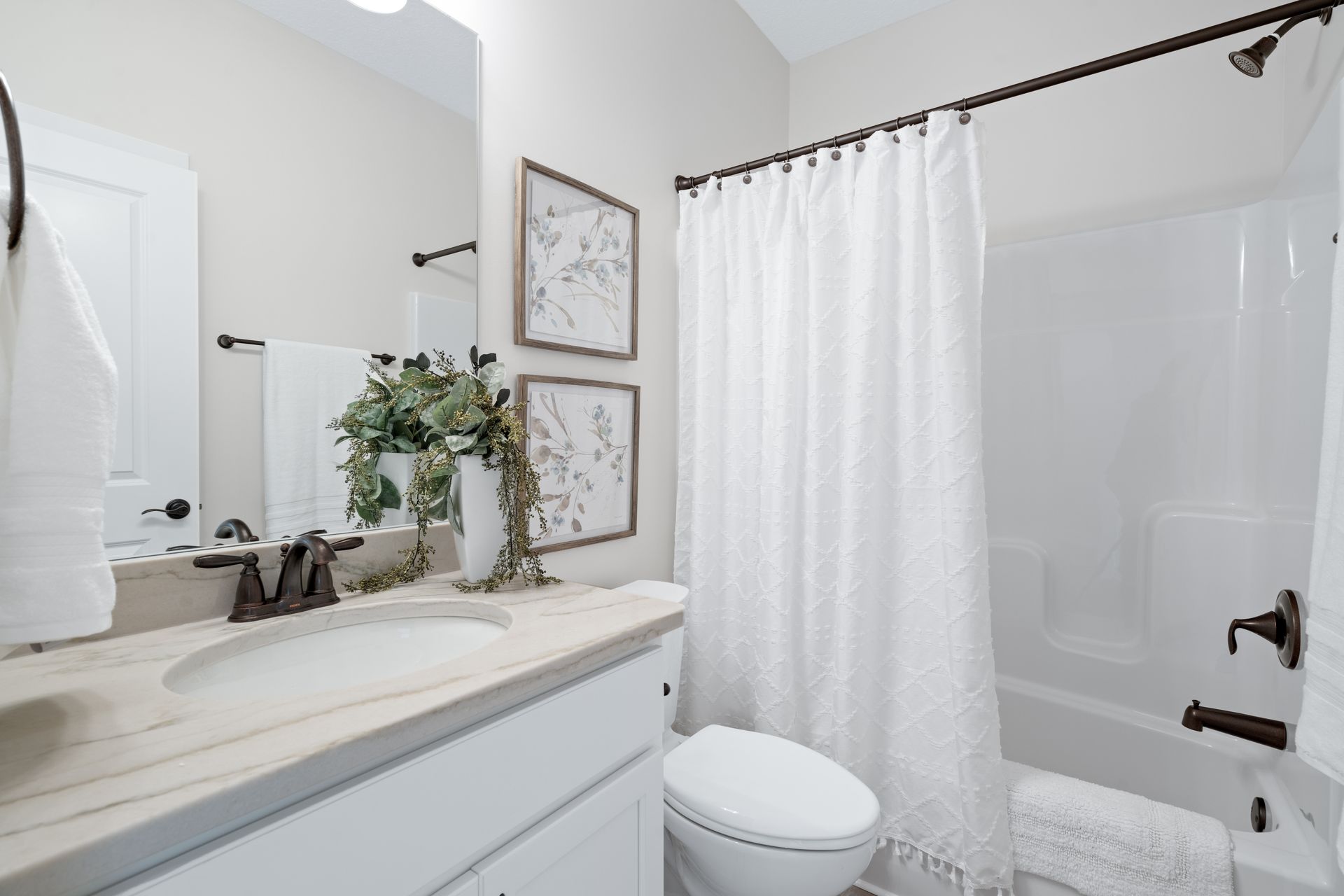 A bathroom with a sink , toilet , bathtub and shower curtain.